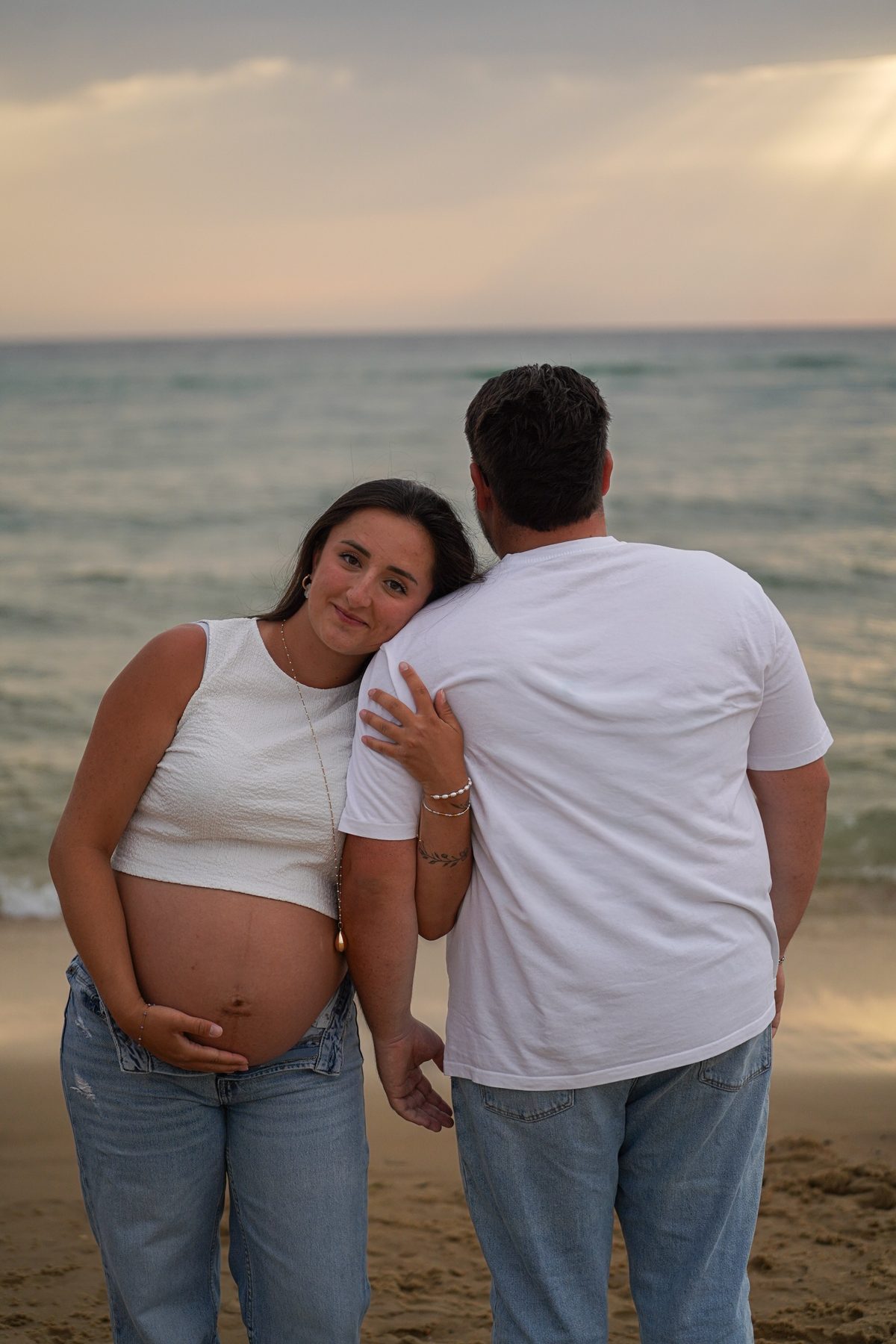 Shooting grossesse Noémie et Romain – Noémie posée contre l'épaule de Romain face à la mer